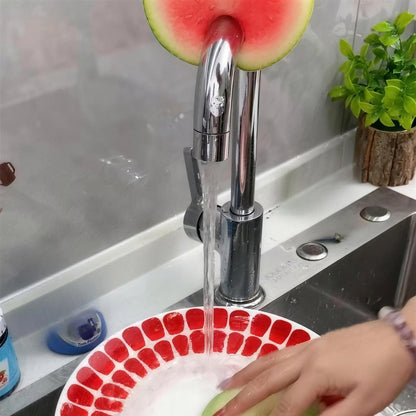 Washing a plate while the guava Frubby hangs on the faucet